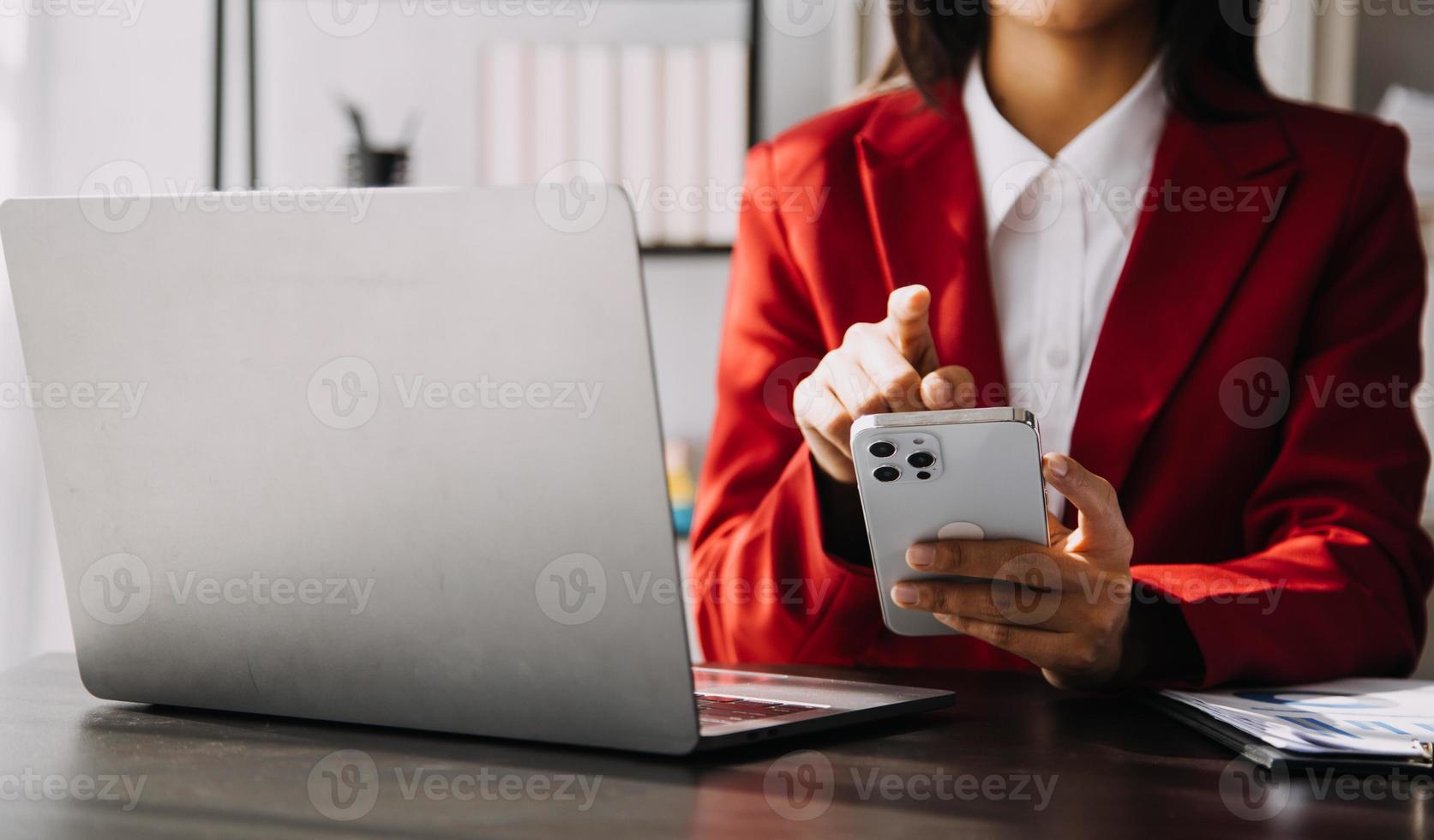 Asian Business woman using calculator and laptop for doing math finance on an office desk, tax, report, accounting, statistics, and analytical research concept photo