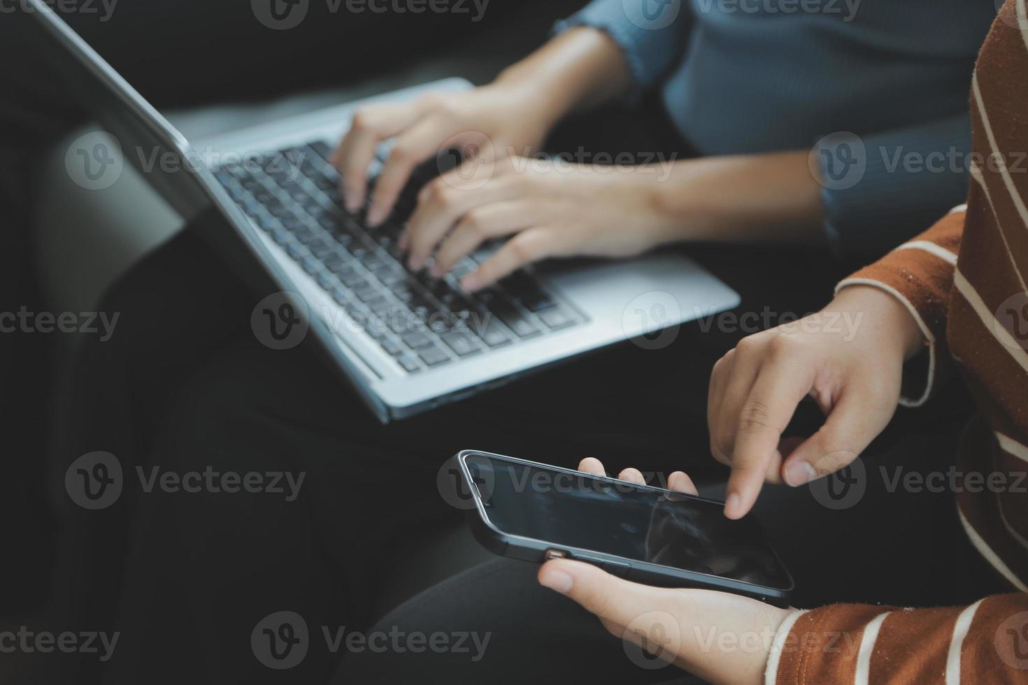 Beautiful woman sitting on a outdoors and using at laptop. Woman and friend having fun with new technology and shopping online at outdoor place. photo