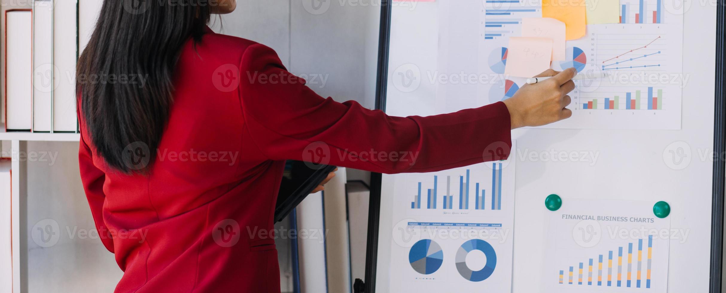 Asian Business woman using calculator and laptop for doing math finance on an office desk, tax, report, accounting, statistics, and analytical research concept photo