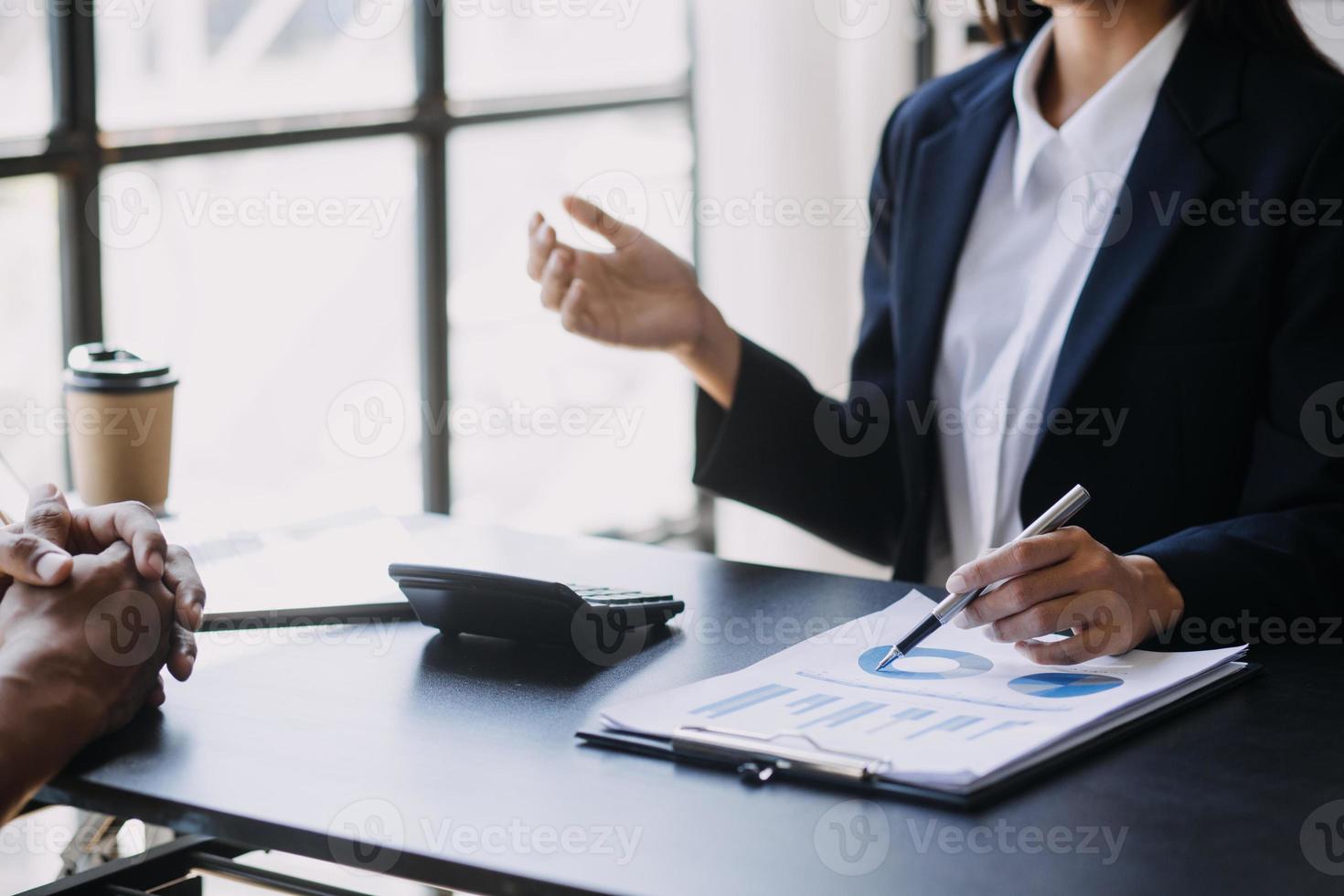 Asian Business woman using calculator and laptop for doing math finance on an office desk, tax, report, accounting, statistics, and analytical research concept photo