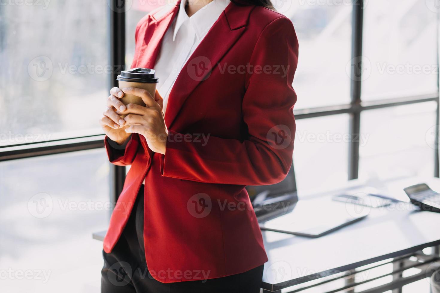 Asian Business woman using calculator and laptop for doing math finance on an office desk, tax, report, accounting, statistics, and analytical research concept photo