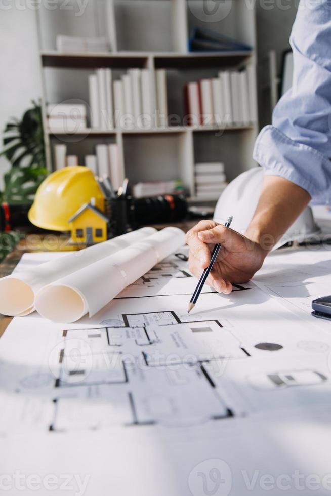 ingeniero de obra de construcción de dos hombres de negocios. objetos de ingeniería en el lugar de trabajo con socios que interactúan en segundo plano foto