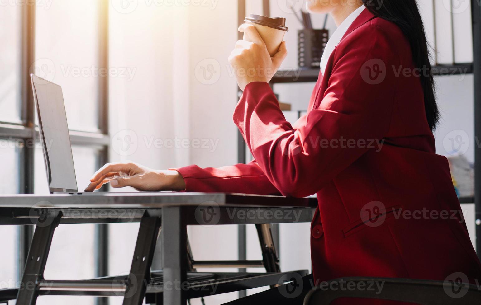Asian Business woman using calculator and laptop for doing math finance on an office desk, tax, report, accounting, statistics, and analytical research concept photo