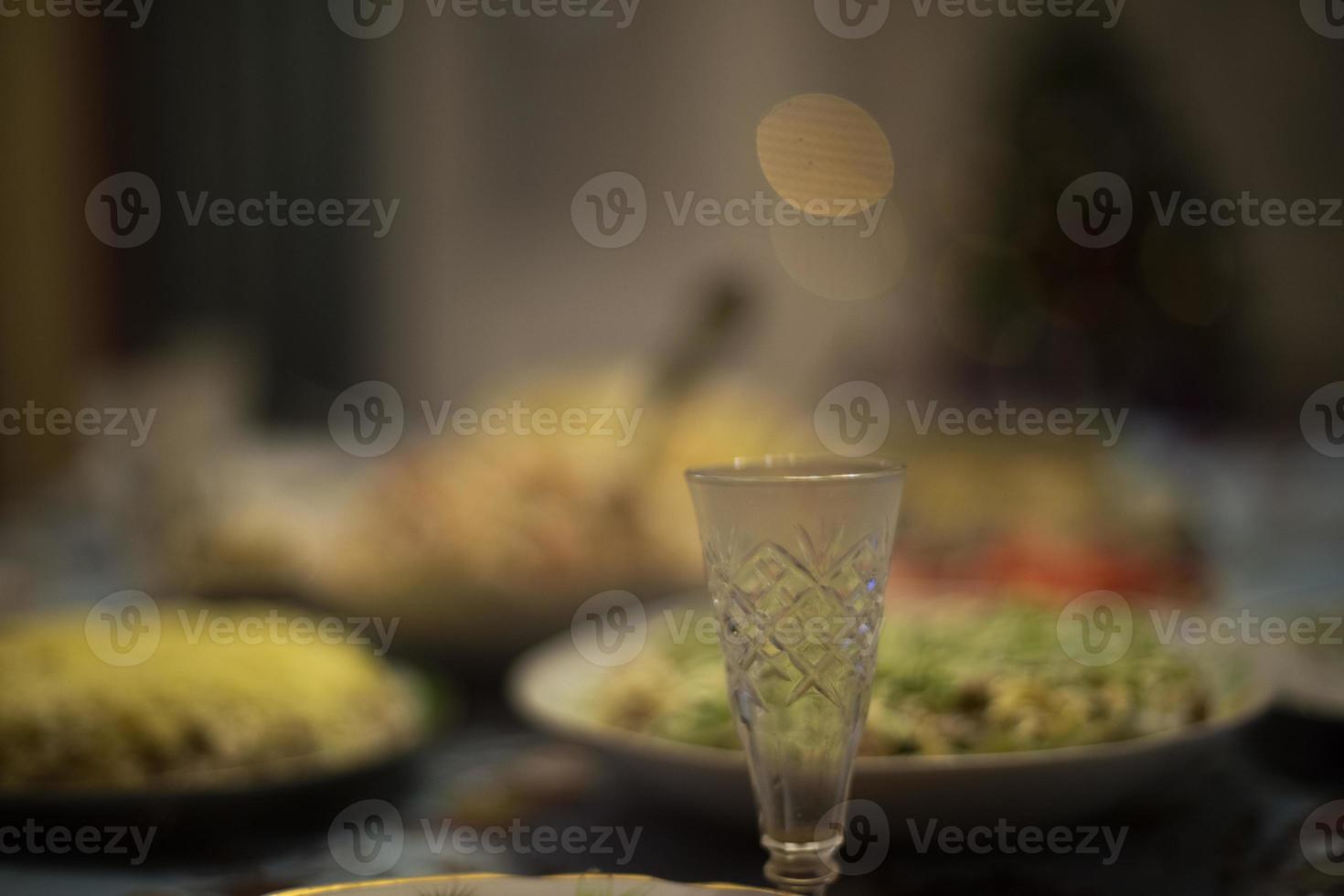Feast in Russia. Glass of vodka on table. Festive table with food. photo