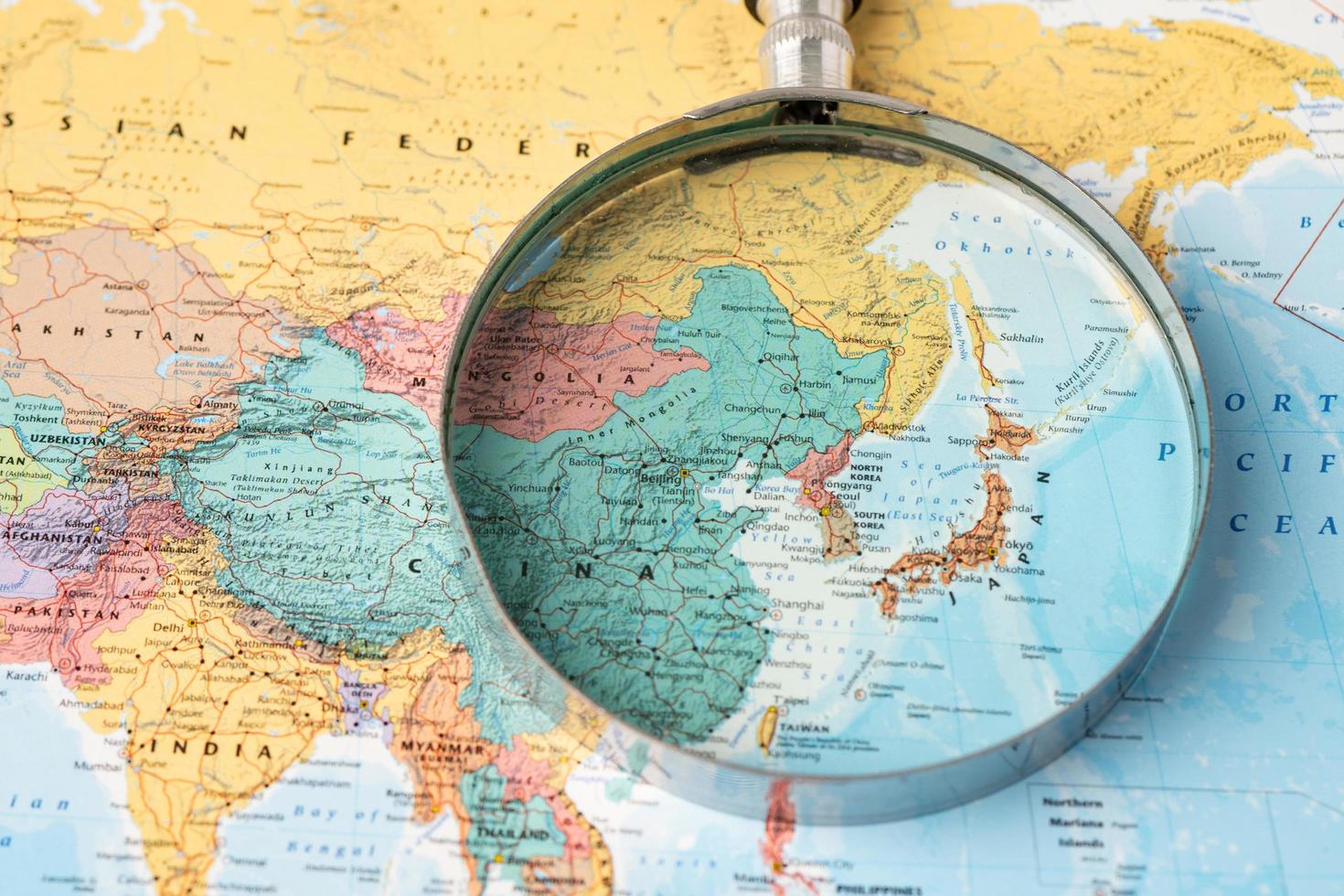Bangkok, Thailand - January 20, 2022 Japan, Magnifying glass close up with colorful world map, travel, geography, tourism and exploration concept. photo