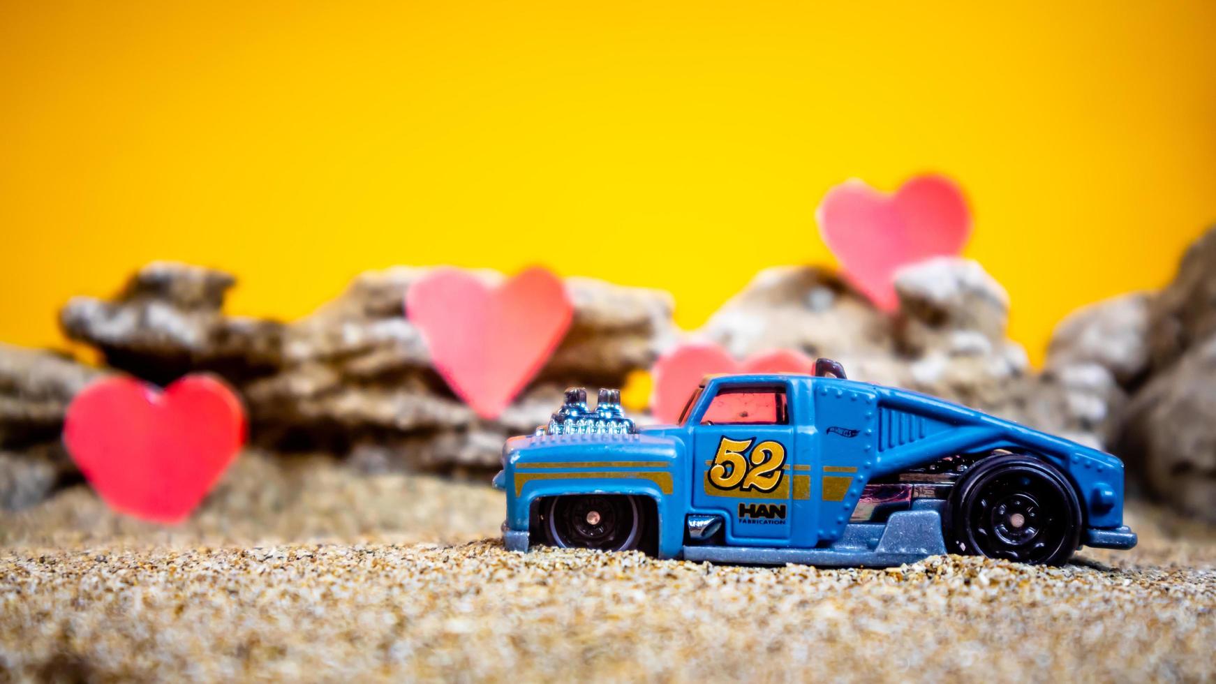 Minahasa, Indonesia  December 2022, toy car with gradient orange background and a heart photo