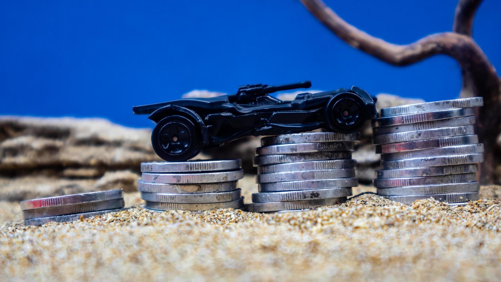 minahasa, Indonesia  January 2023, toy car on a pile of coins, saving for the future, managing successful transportation business technology concept photo