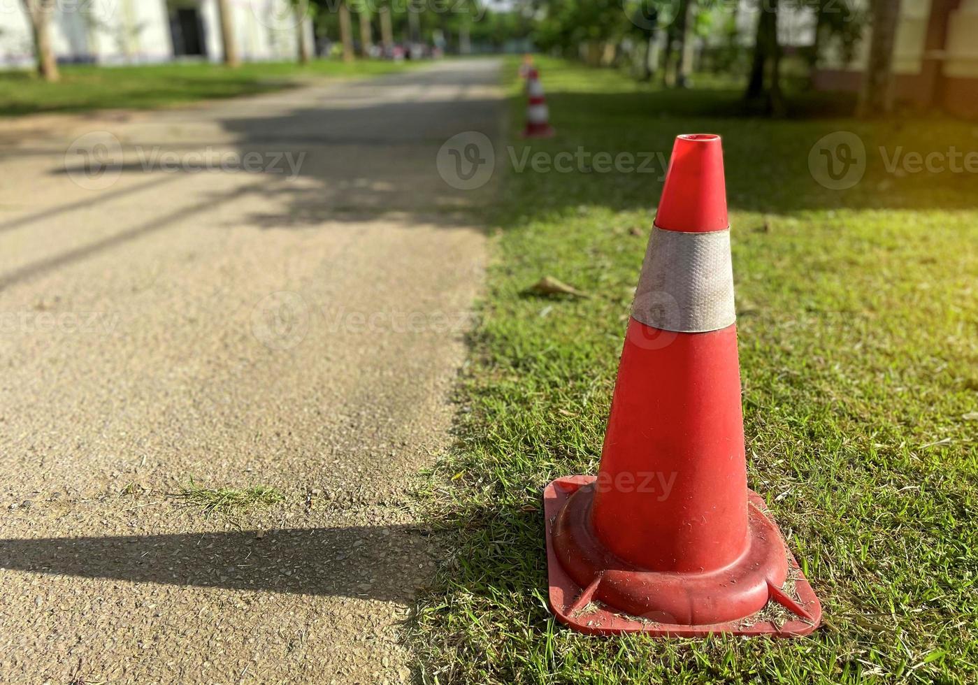 Traffic cones lay on the side of the road. Set up to designate a parking prohibited area along the line because it obstructs the exit. Soft and selective focus. photo