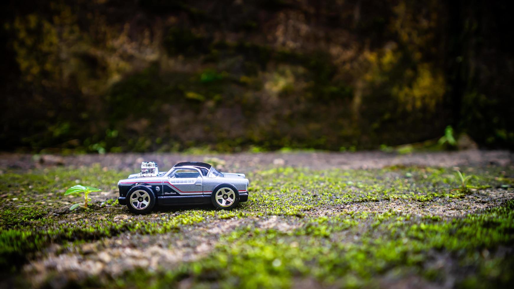 South Minahasa, Indonesia  January 2023, a toy car on a mossy floor that looks like grass photo