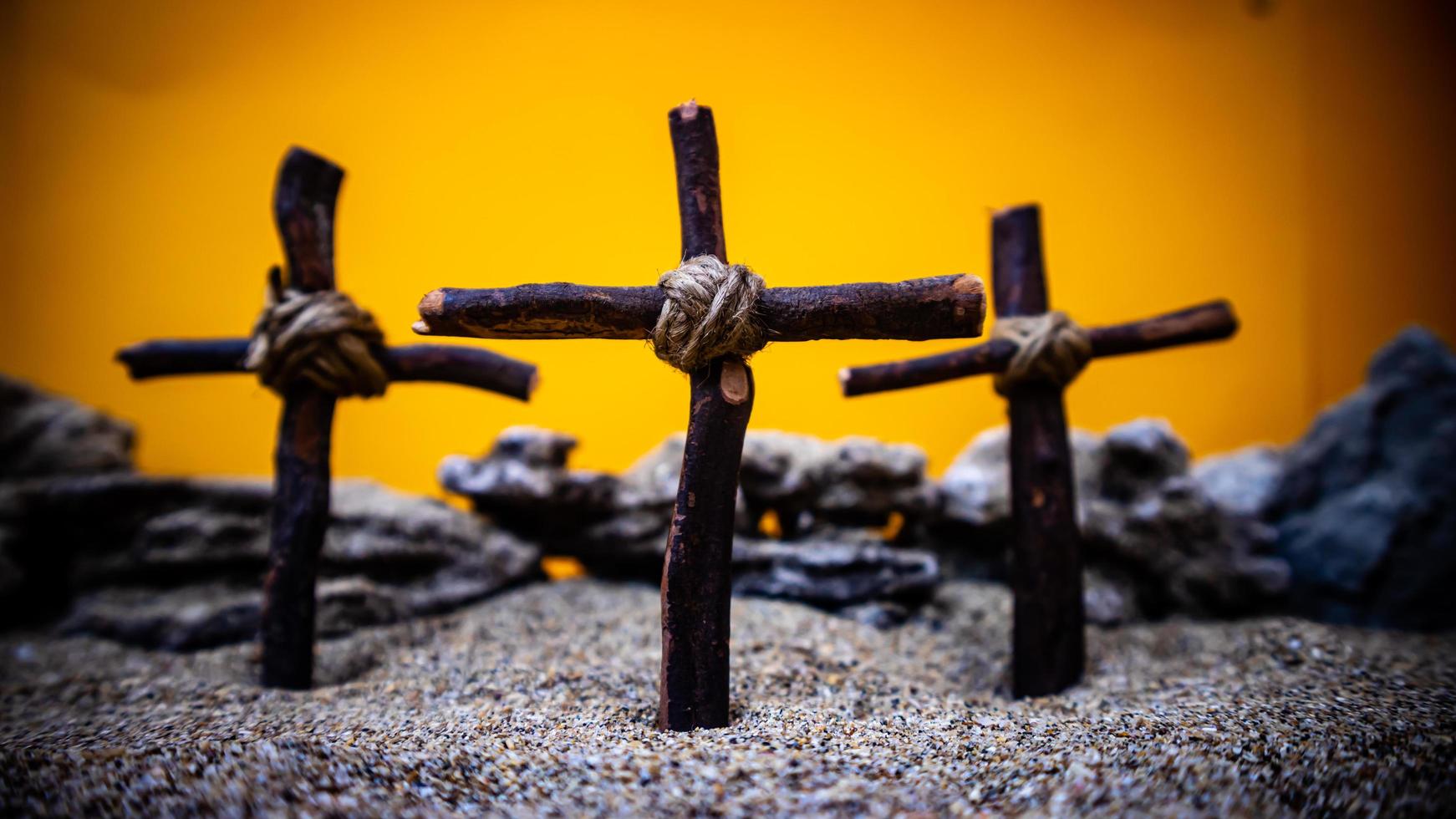 crosses stuck in the sand on an orange background photo