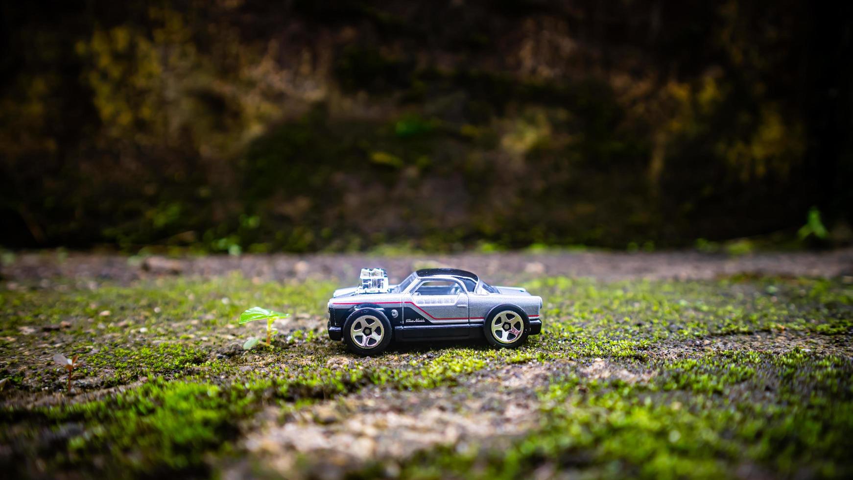 South Minahasa, Indonesia  January 2023, a toy car on a mossy floor that looks like grass photo