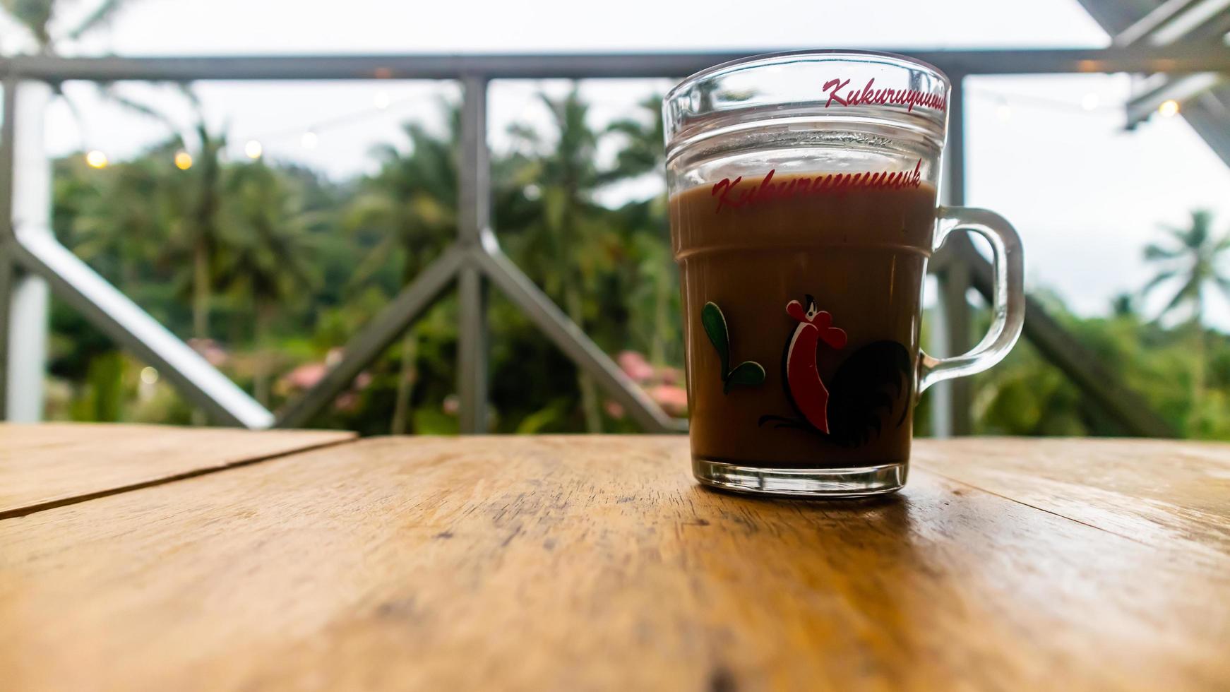 a cup of coffee on a wooden table photo