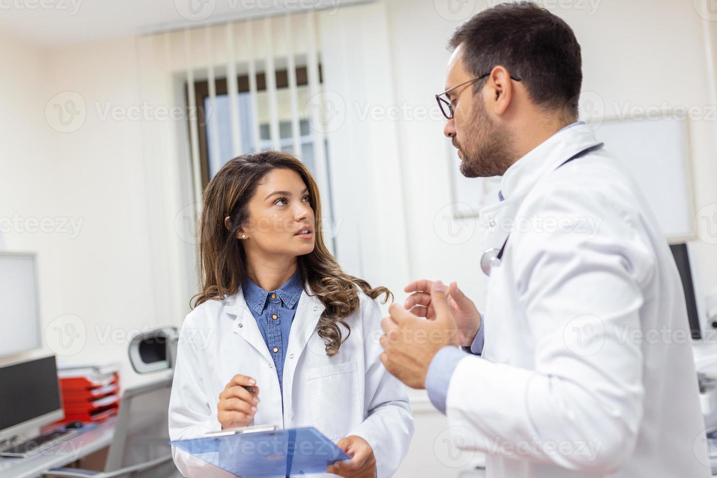 doctores que se discute terminado un médico reporte en hospital. hembra y masculino médico comprobación clínico reporte de paciente en línea. cuidado de la salud personal teniendo discusión en un oficina de privado clínica. foto