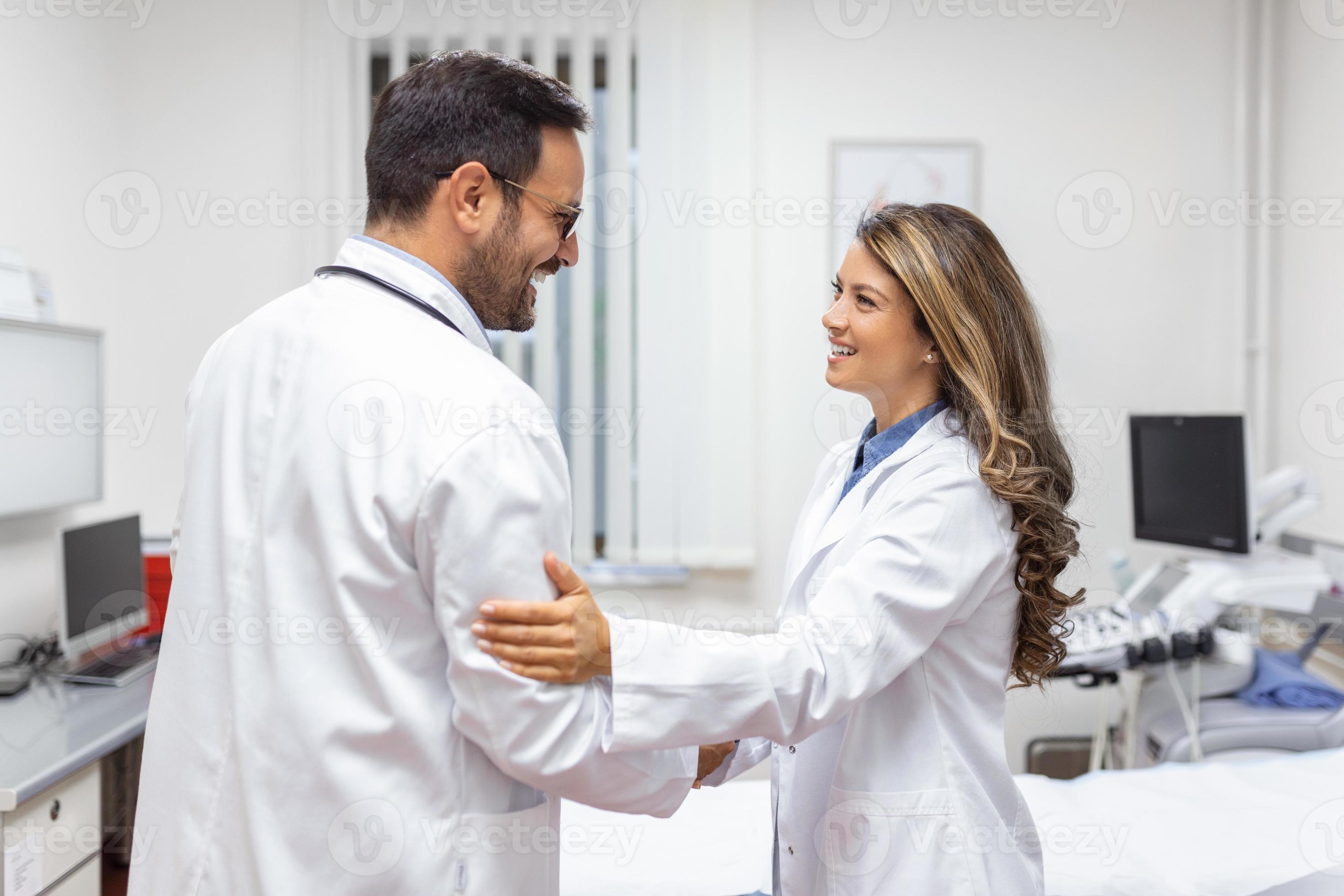 Two Professional confident doctor shaking hands while standing at the