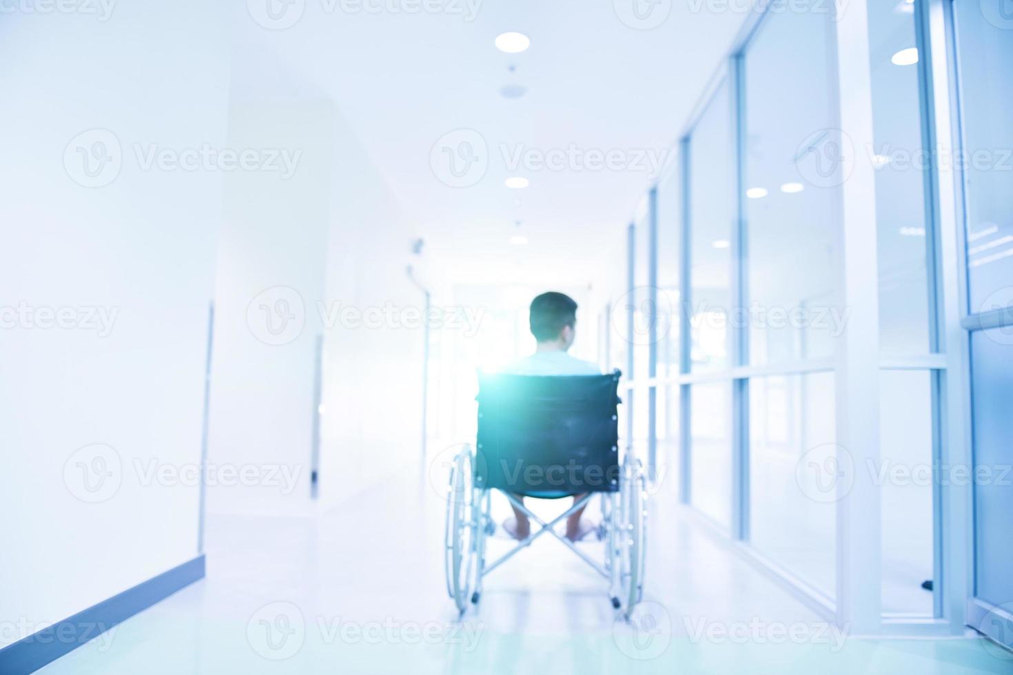 Child in wheelchair, sick person in hospital, blurred image of patient sitting in wheelchair photo