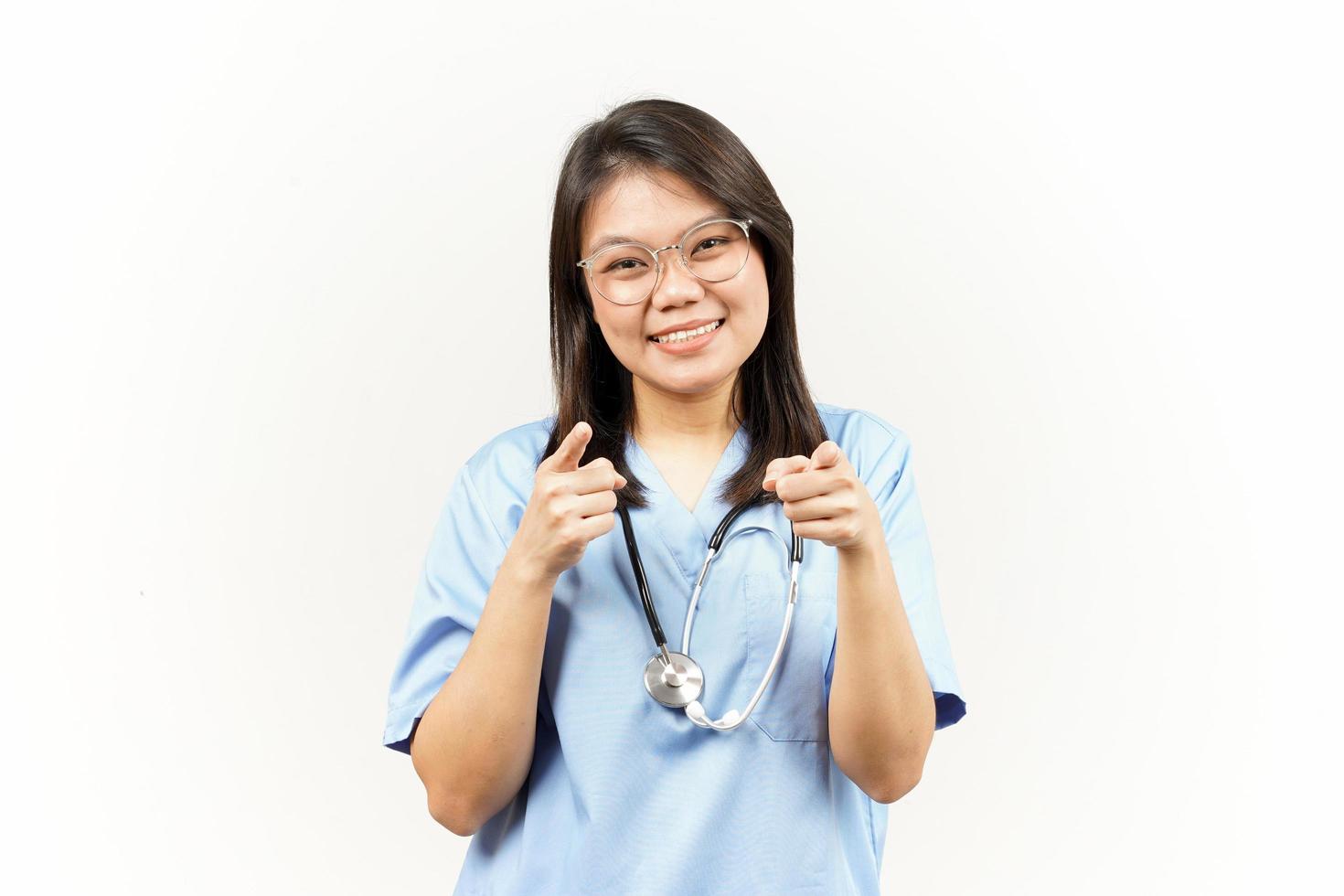 Smiling and Pointing at You, Want You Gesture Of Asian Young Doctor Isolated On White Background photo