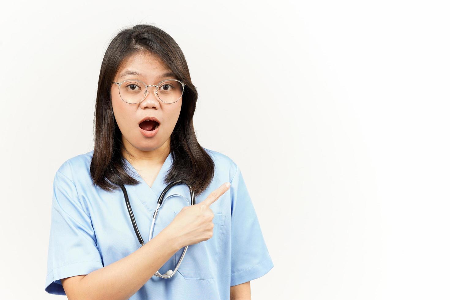 Showing Product and Pointing Side Of Asian Young Doctor Isolated On White Background photo