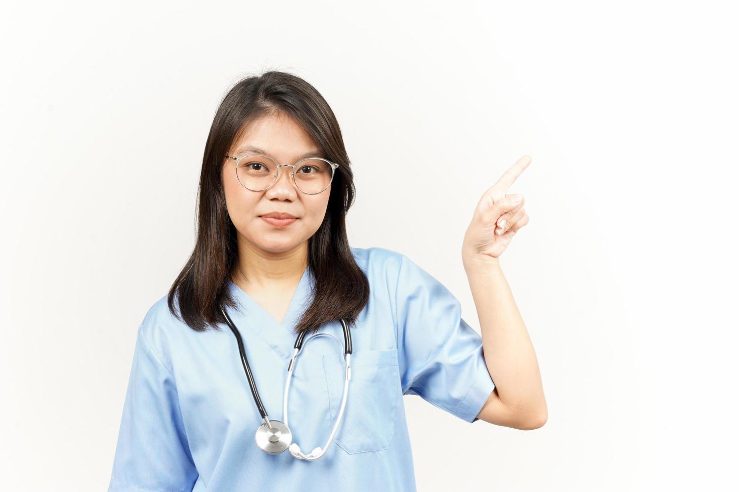 Showing Product and Pointing Side Of Asian Young Doctor Isolated On White Background photo