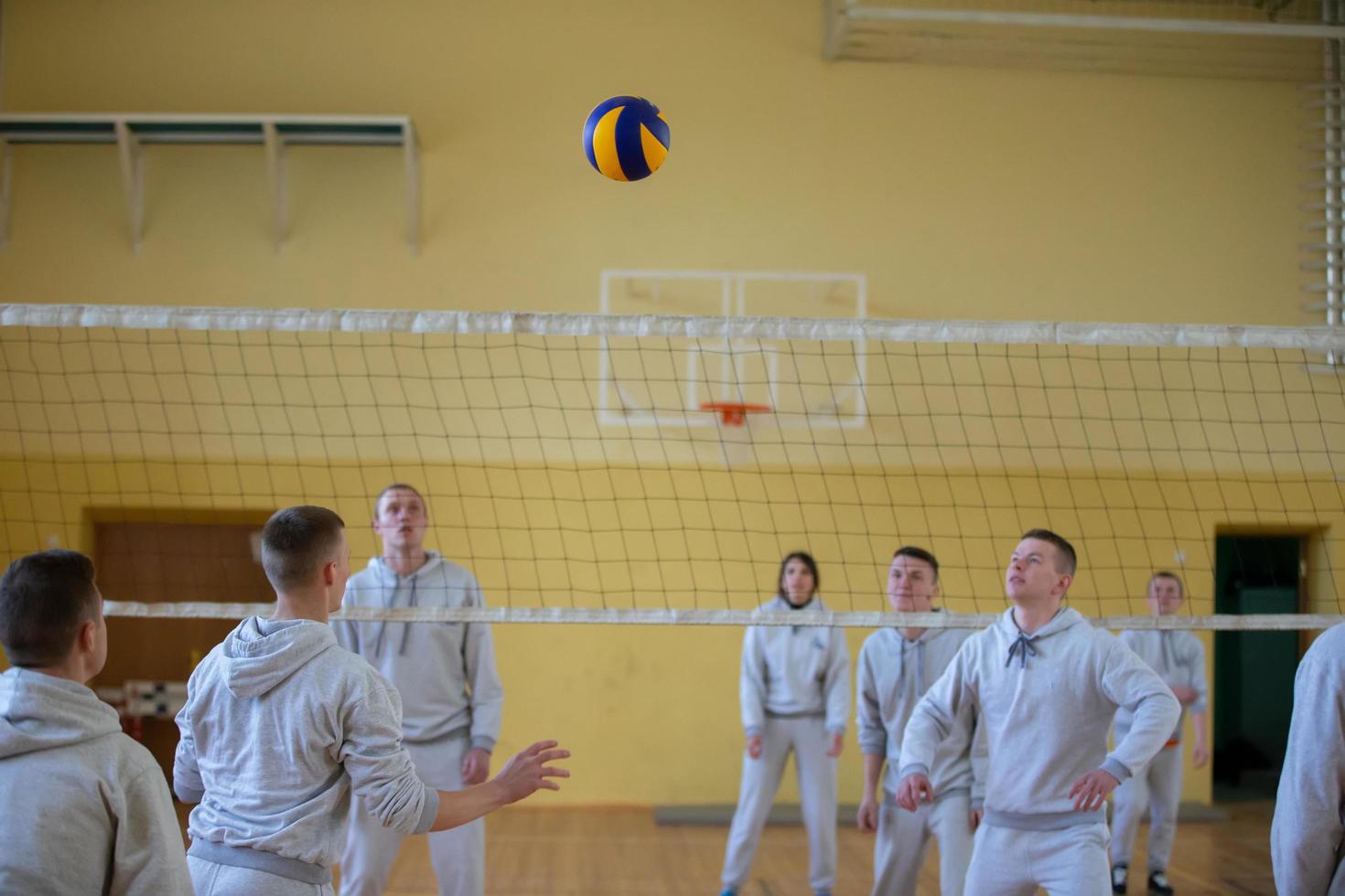 An open lesson in the college of physical education. People play volleyball in the gym. photo