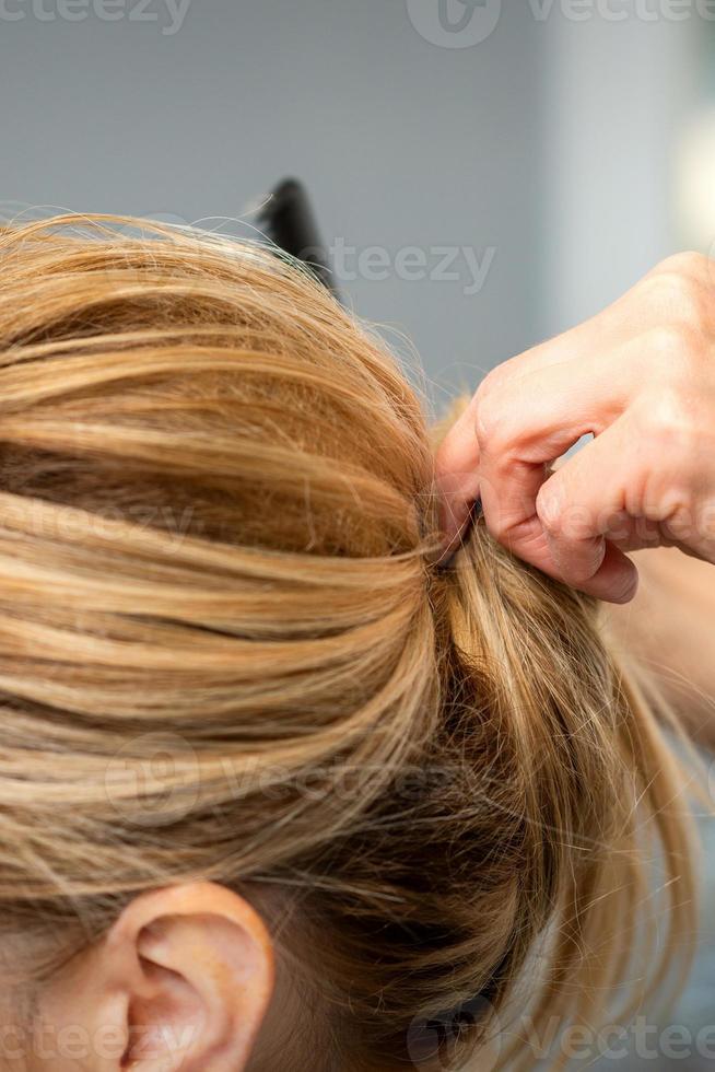 Hairdresser styling hair of woman photo