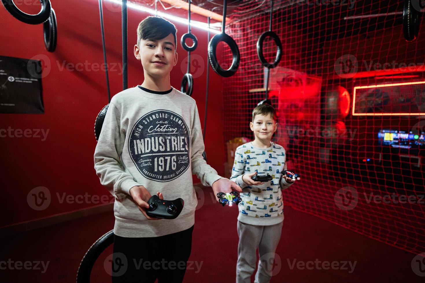 Children flying remote control drones game indoor play zone. photo