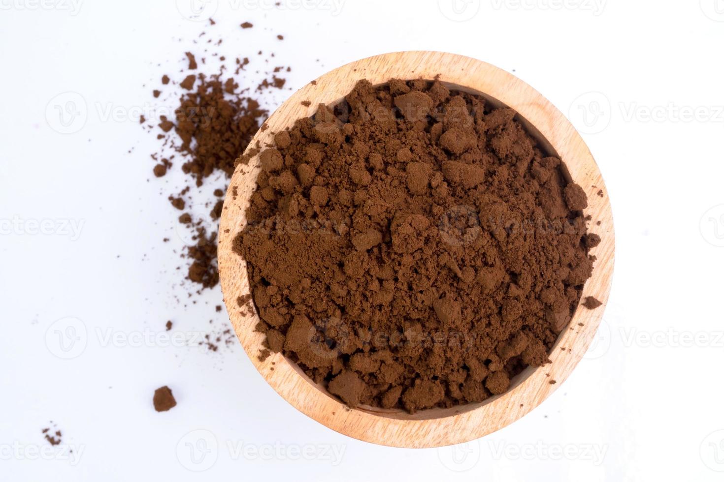 Coffee grounds in a wooden bowl isolated on white background. photo