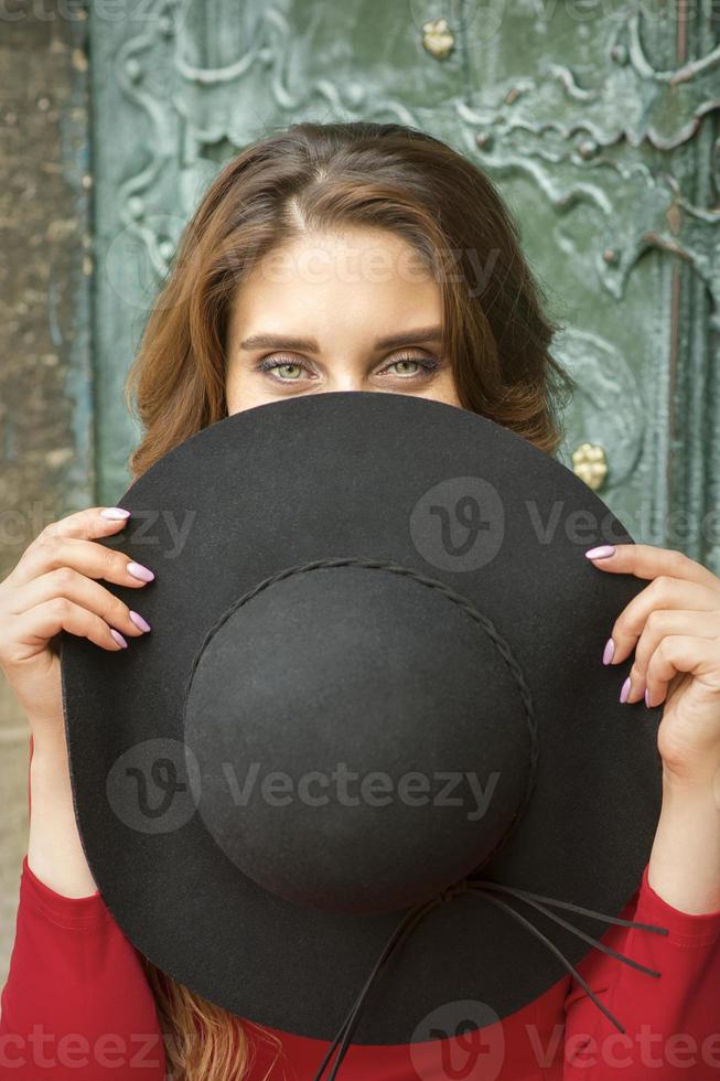 Woman hiding face with hat photo