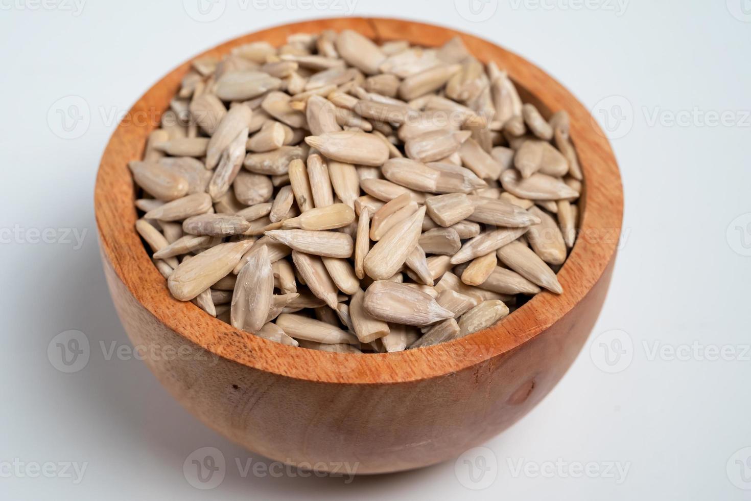 Sun flower seed on wood bowl isolated on white background photo