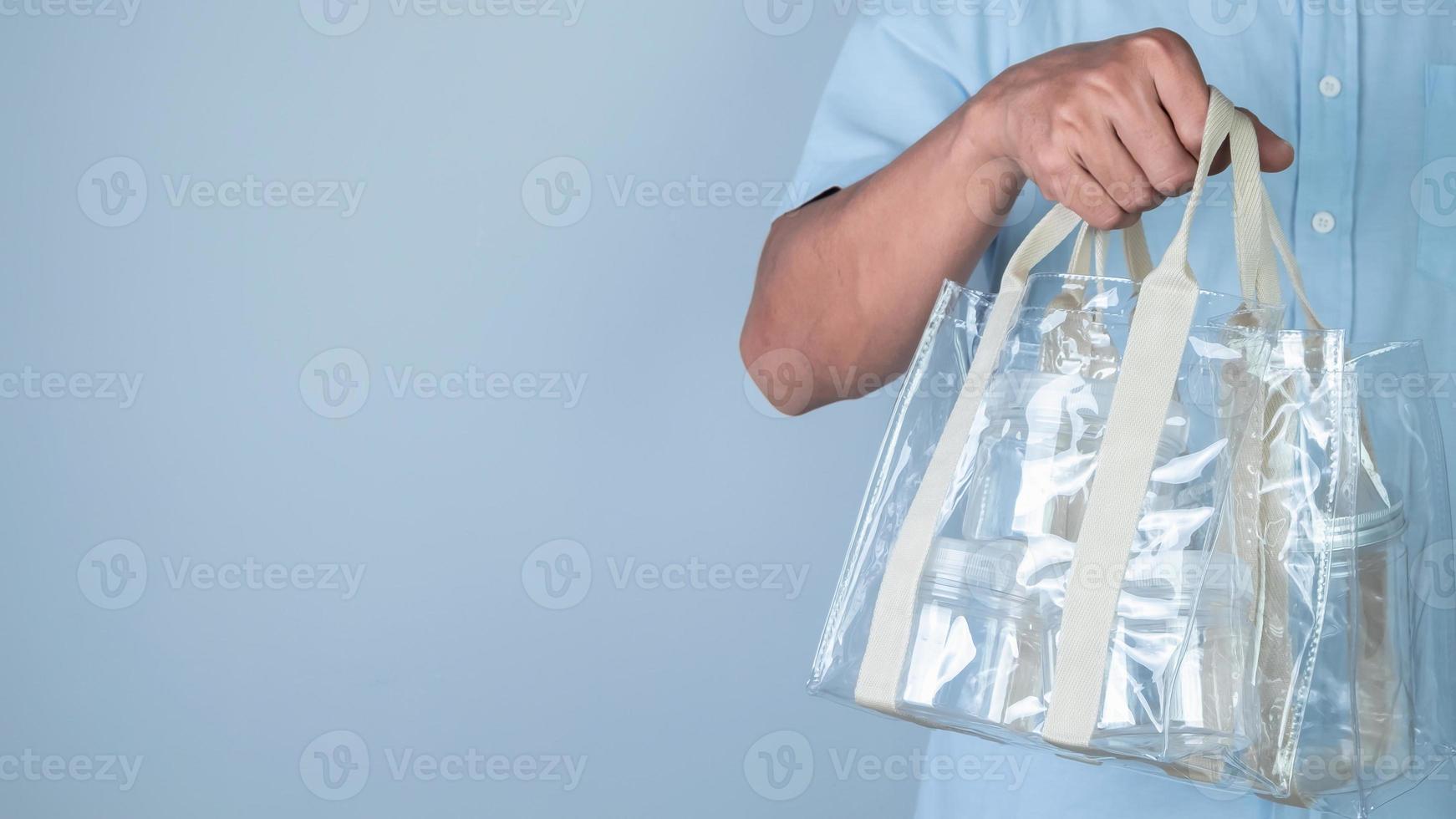 Hand holding plastic bag on blue background, Recycling concept. photo