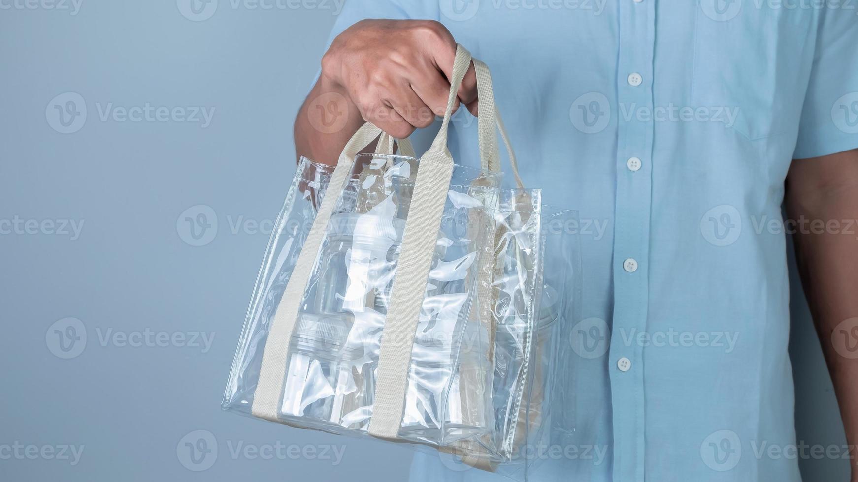 Hand holding plastic bag on blue background, Recycling concept. photo