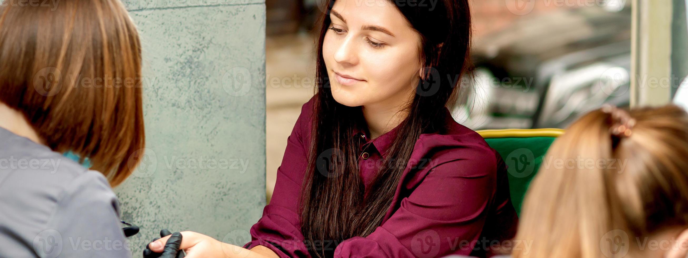 Young woman receiving nail treatment photo