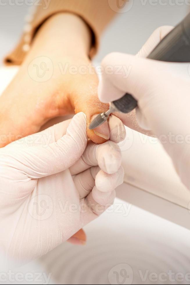 Manicurist removing old nail polish photo