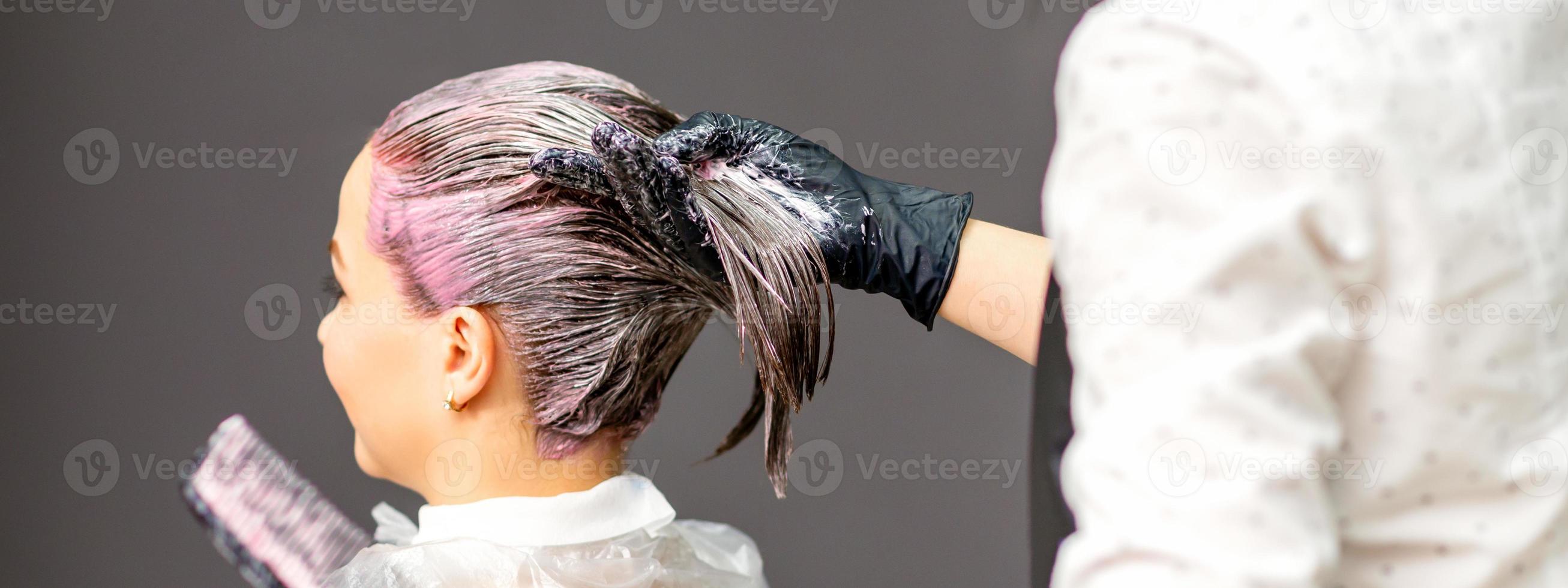 Hairdressers dyeing hair of woman photo