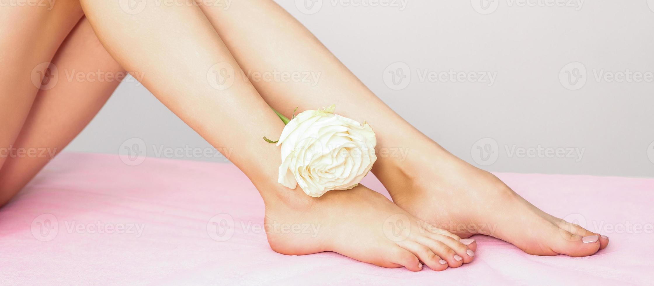Female legs with white rose photo