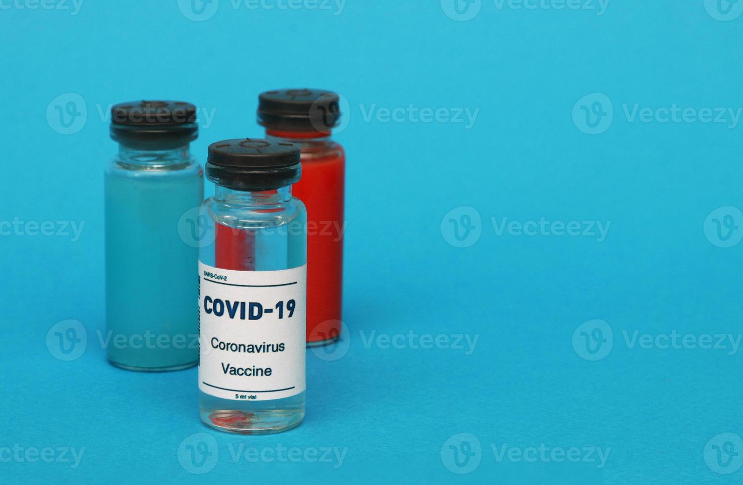 Three medical ampoules on a blue background. photo