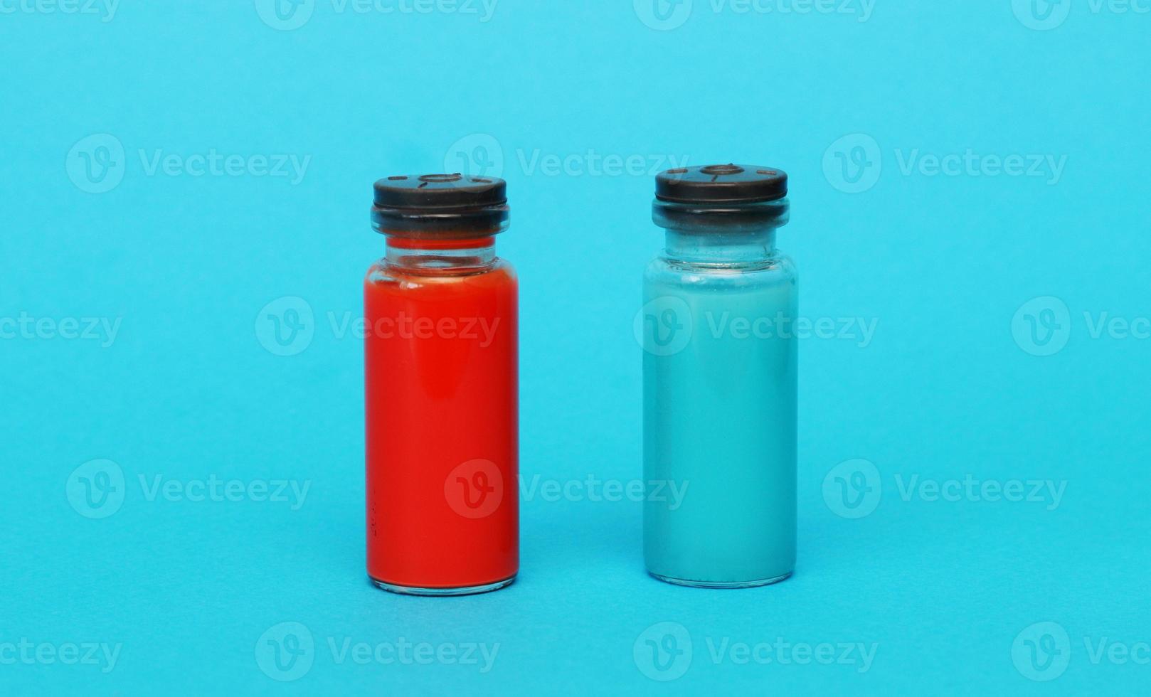 dos médico vaso botellas con azul y rojo líquido. foto