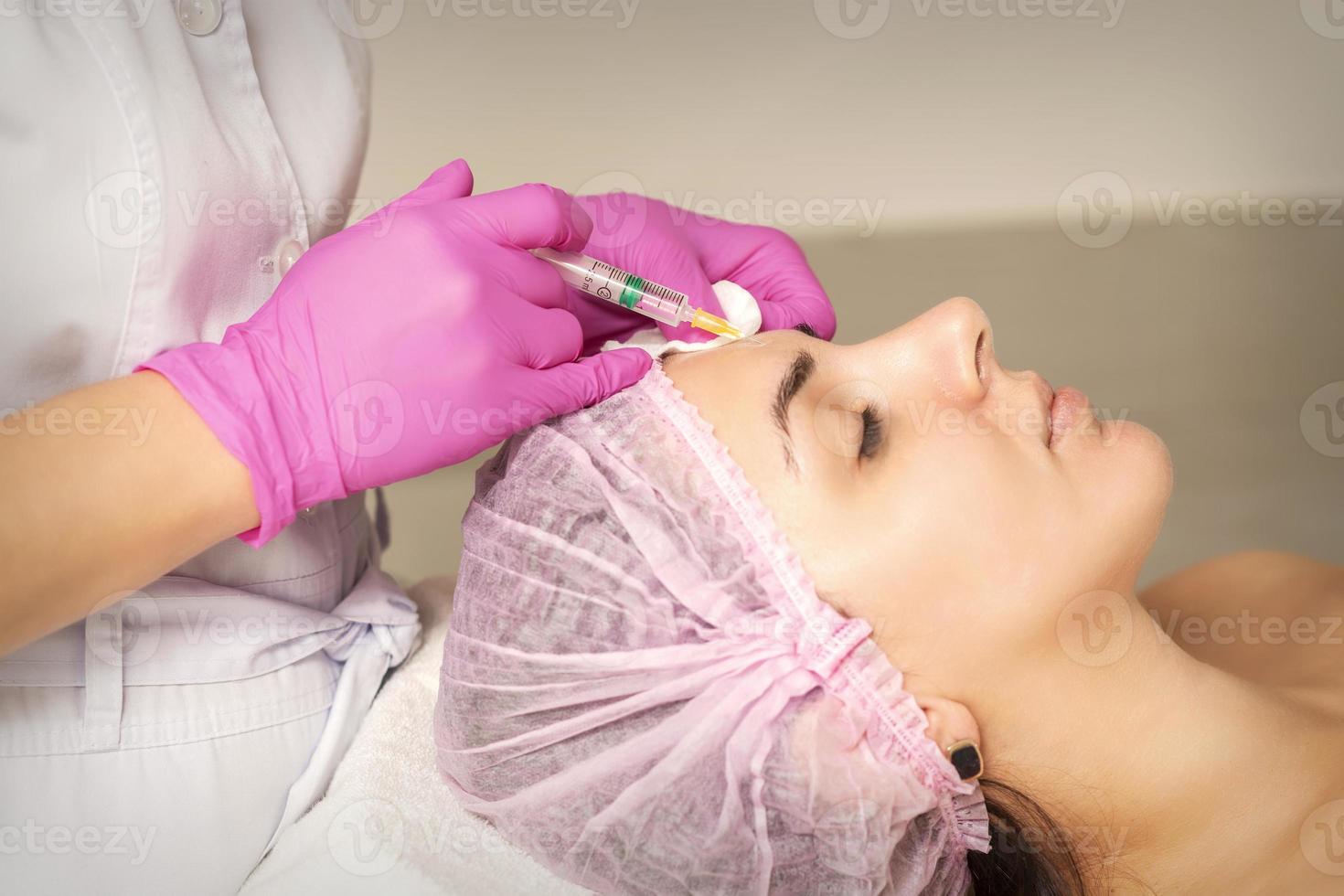 Woman receiving injection of botox photo