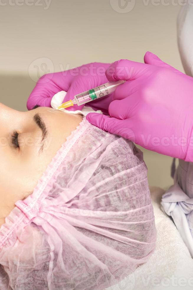 Woman receiving injection of botox photo