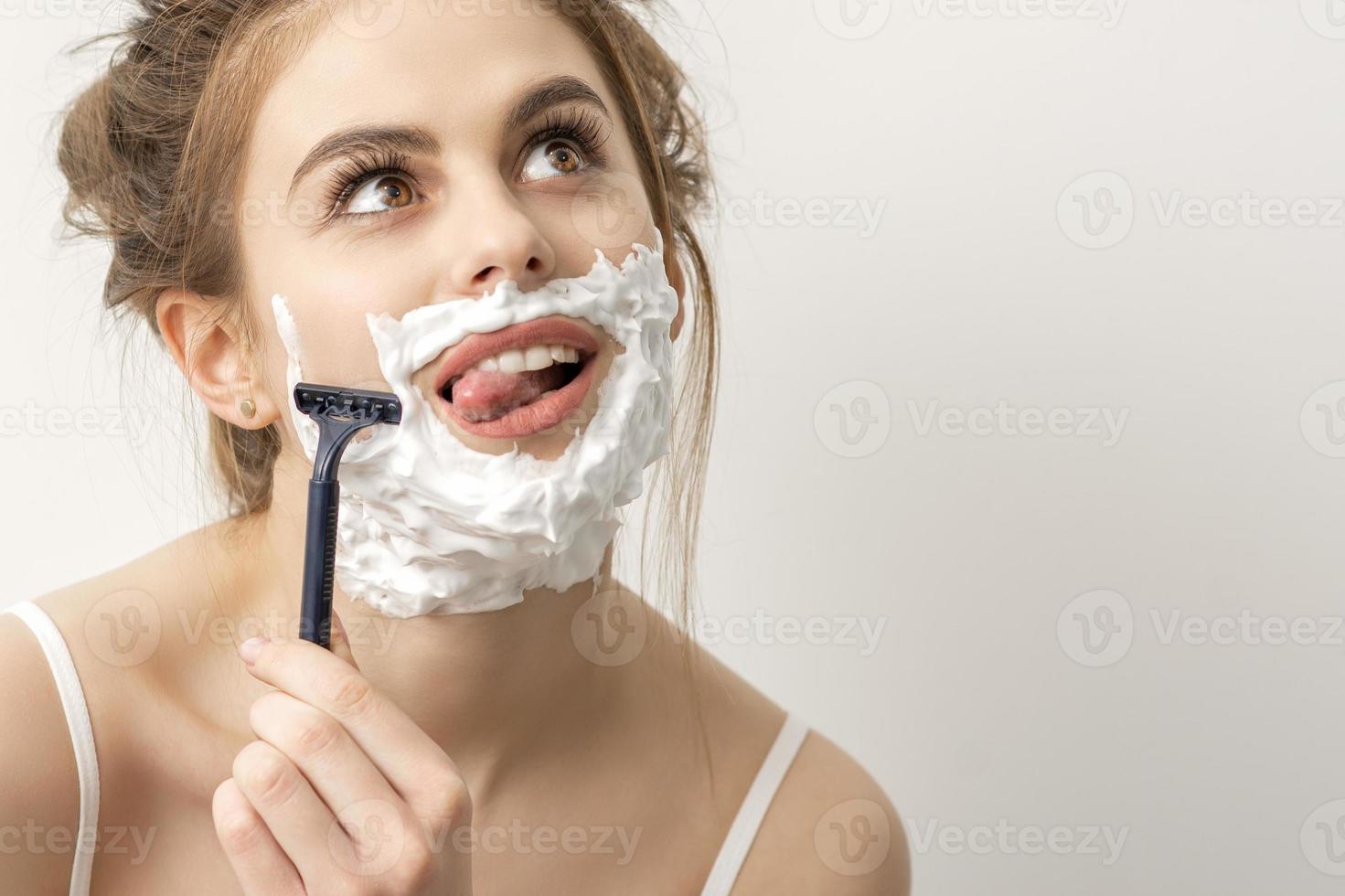 mujer afeitado cara con maquinilla de afeitar foto