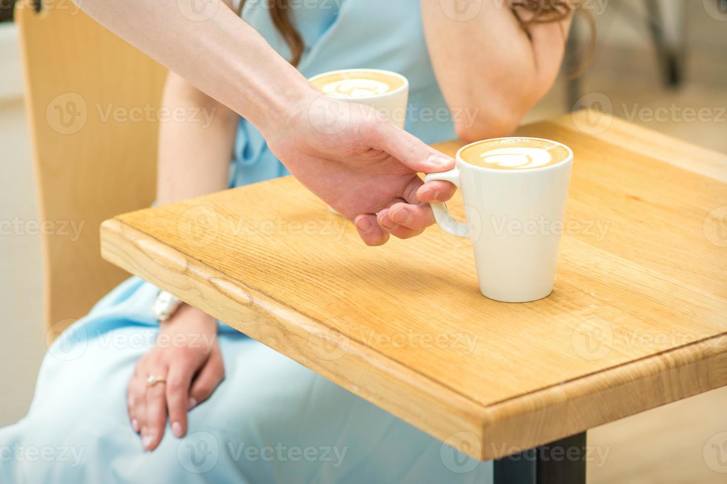 Waiter puts a cup of coffee photo