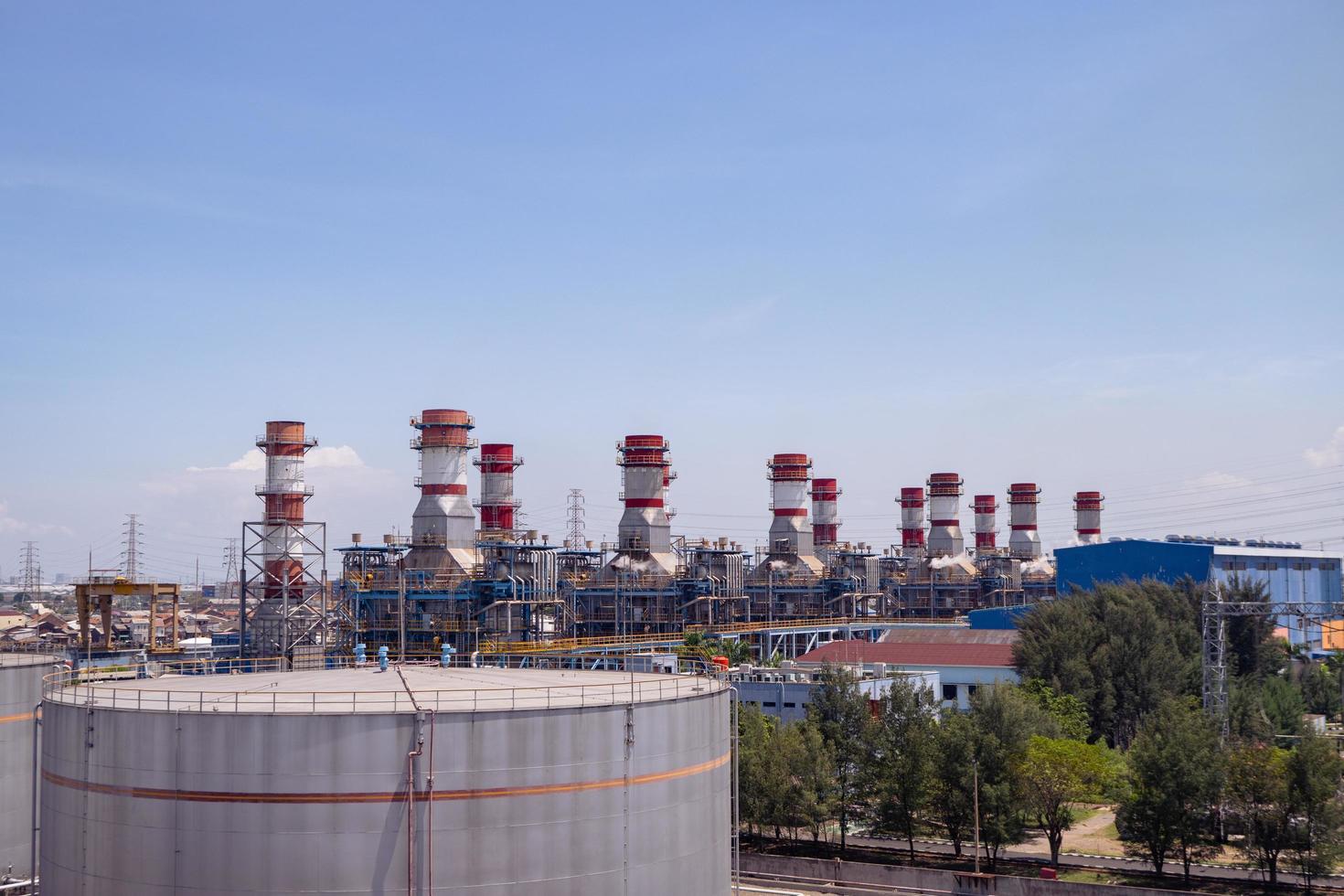 aerial view of combine cycle project power plant when day time with blue sky and cloudy vibes. The photo is suitable to use for industry background photography, power plant poster and electricity.