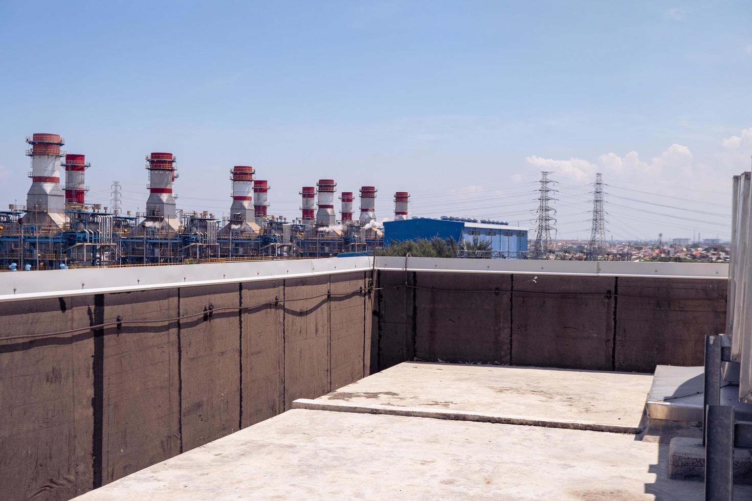 Landscape photo of roof top power plant building with blue sky. The photo is suitable to use for industry background photography, power plant poster and electricity content media.