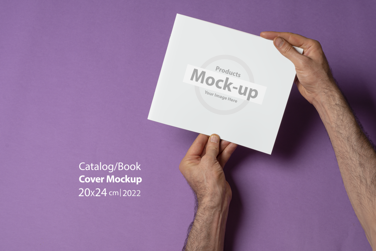 Male hand holding a catalog with blank cover on purple background psd