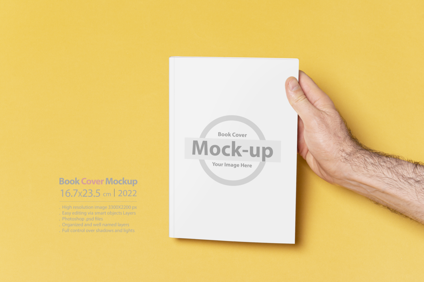 Male hand holding a closed book-catalog with blank cover on yellow background psd