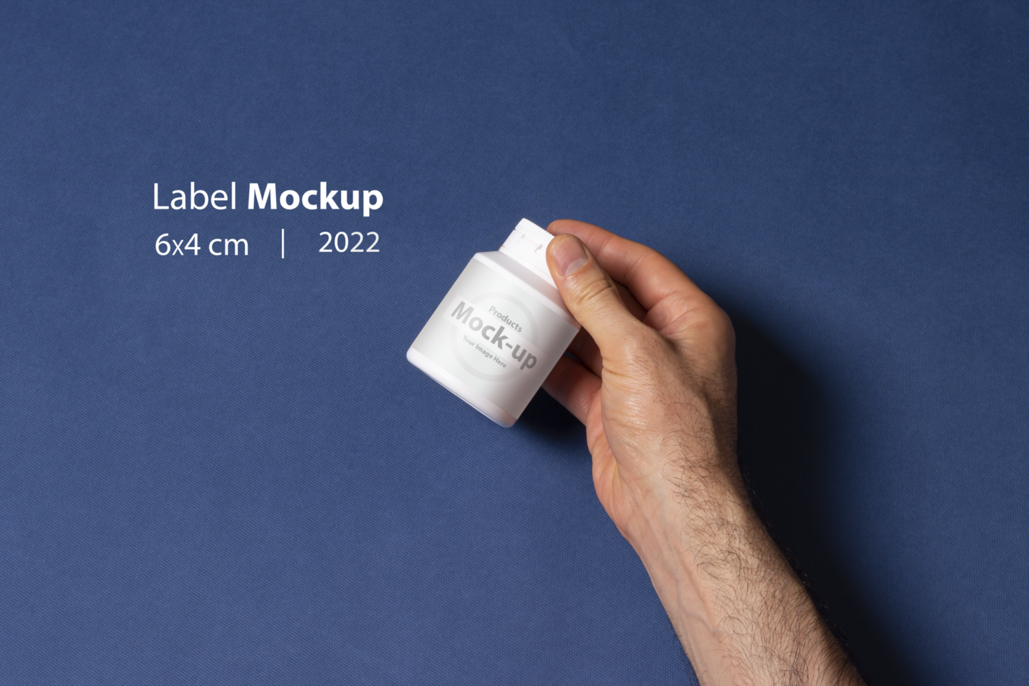 Male hand holding a white pillbox bottle in front of blue background psd