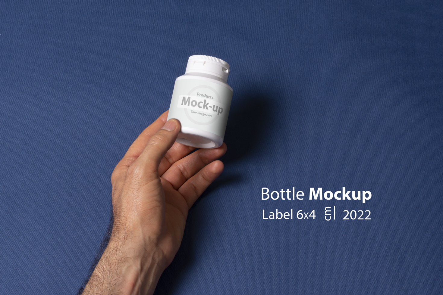 Male hand holding a white pillbox bottle in front of blue background psd
