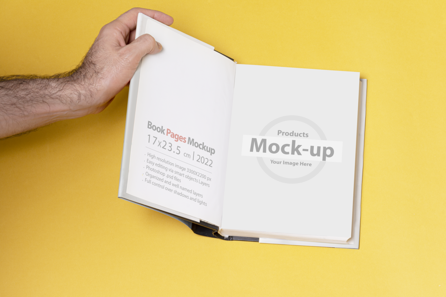Male hand opened a book-catalog on yellow background psd