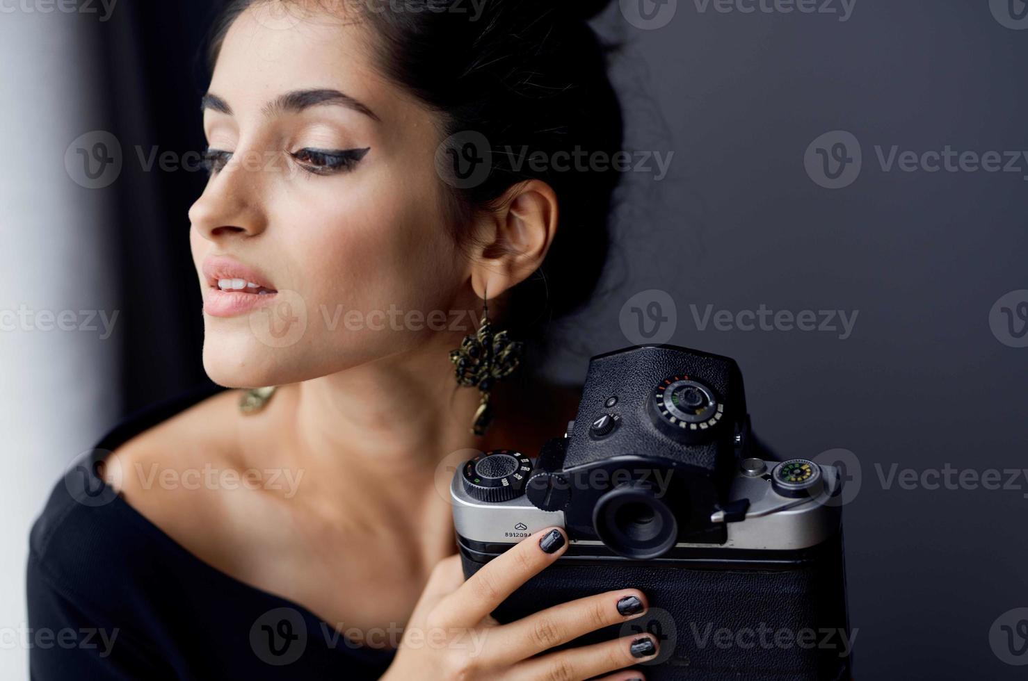 pretty woman holding a camera near the window decoration fashion lifestyle studio photo