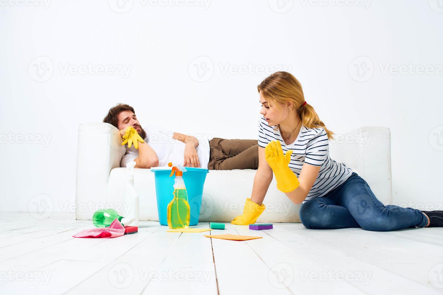 young couple at home near sofa washing supplies cleaning lifestyle photo