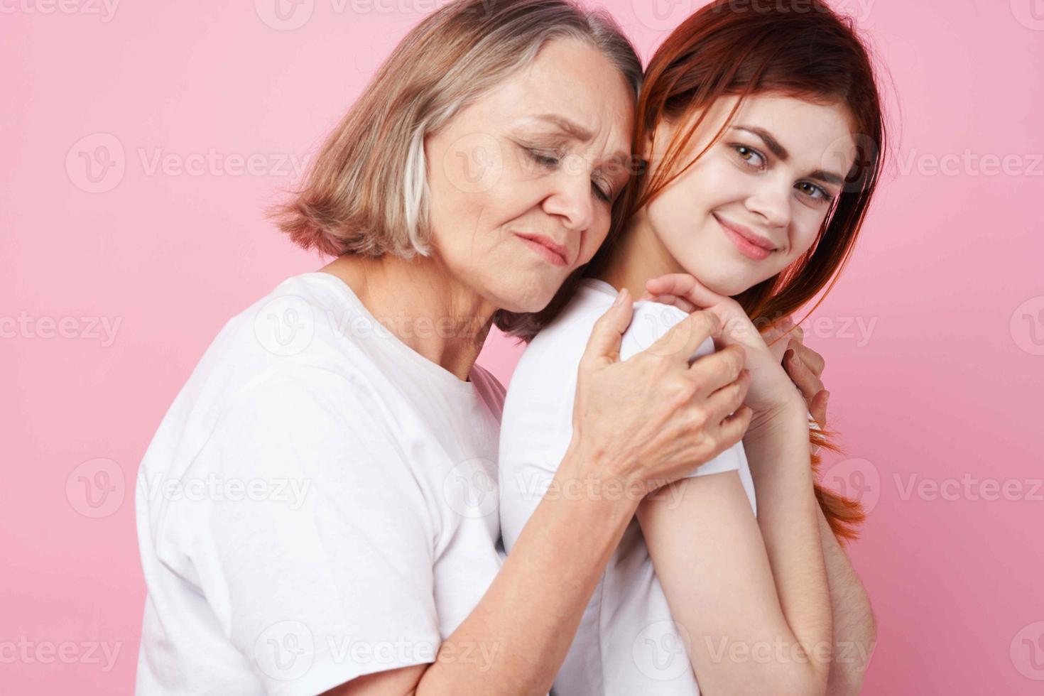 grandmother and granddaughter close communication together love pink background photo